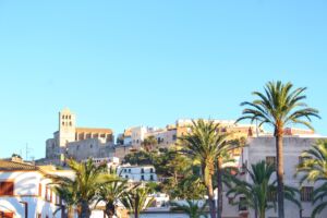 Ibiza old town skyline in summer. Holiday destination with blue sky and palm trees